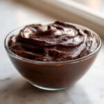 A close-up of thick, rich Vegan Chocolate Chia Pudding swirled in a clear glass bowl.