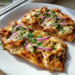 Two slices of freshly baked BBQ Chicken Flatbread Pizza topped with melted cheese, red onion, and parsley.