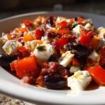Close-up of a vibrant Chopped Italian Antipasto Salad featuring chunks of mozzarella, red peppers, and black olives.