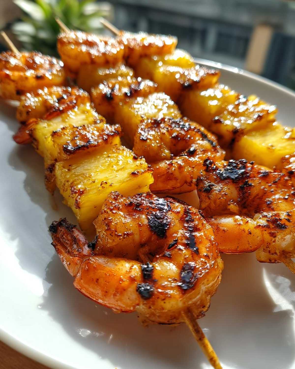 Close-up of perfectly grilled pineapple shrimp skewers, showing caramelized shrimp and charred pineapple chunks.