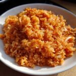 Close-up of a white bowl filled with vibrant, fluffy Mexican Rice with Roasted Garlic.
