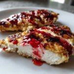 Close-up of a sliced Strawberry Goat Cheese Chicken Cutlet showing the creamy filling and bright red strawberry topping.