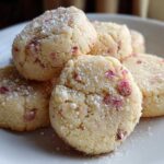 A stack of freshly baked Strawberry Lemon Shortbread Cookies dusted with powdered sugar on a white plate.