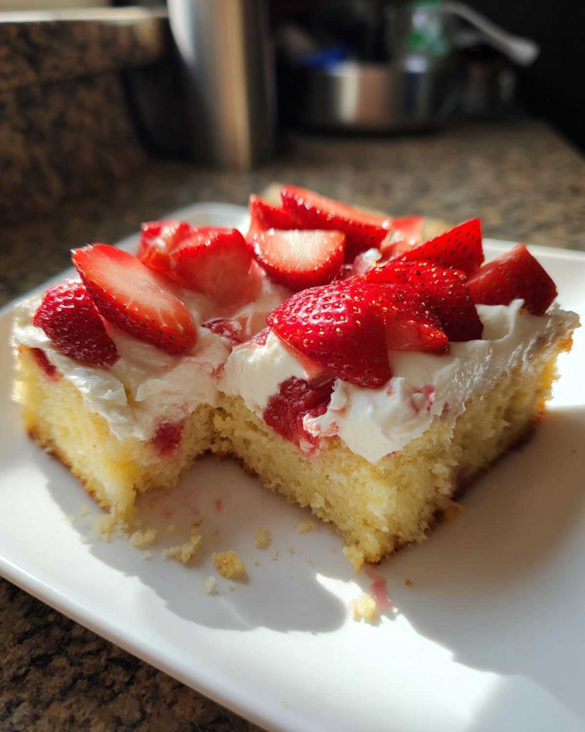 A close-up of a slice of Strawberry Vanilla Sheet Cake with Fresh Berries topped with whipped cream.