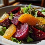 Close-up of a vibrant Roasted Beet Orange Salad featuring deep red beets, bright orange slices, and mixed greens.